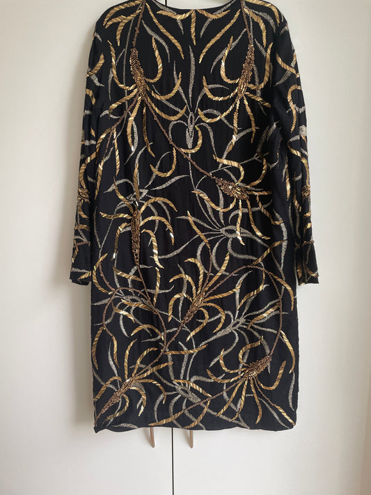 Vestido negro bordado con espigas de trigo dorado.